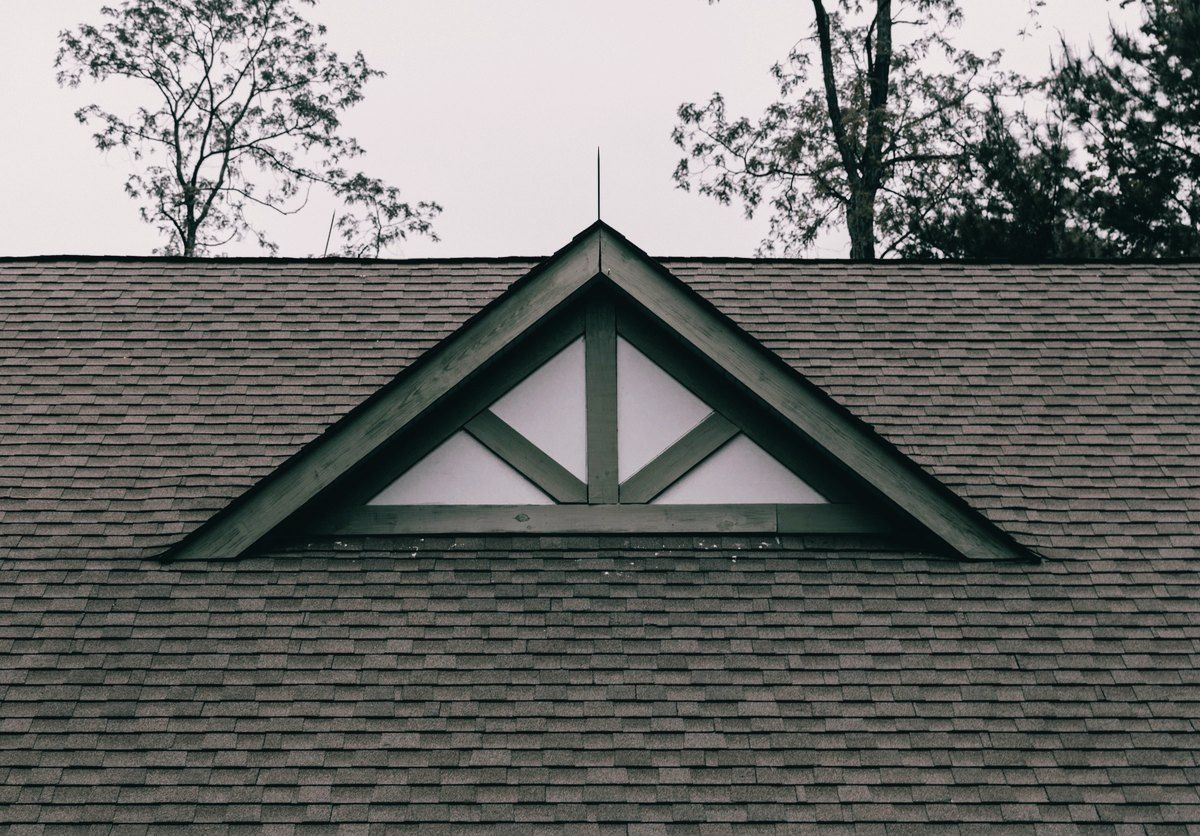 A finished architectural shingle roof with a gable vent